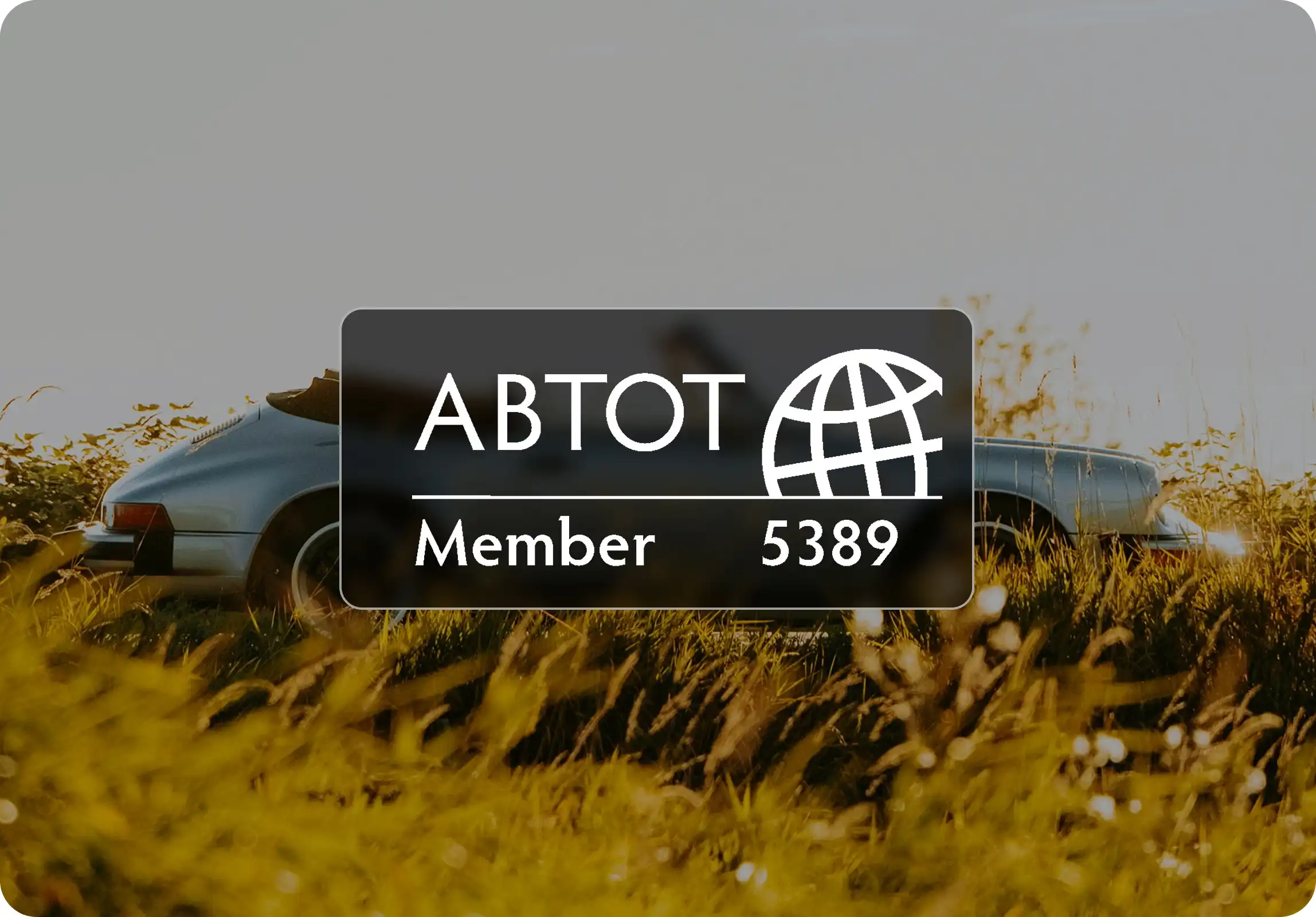 ABTOT membership badge over a car in a field